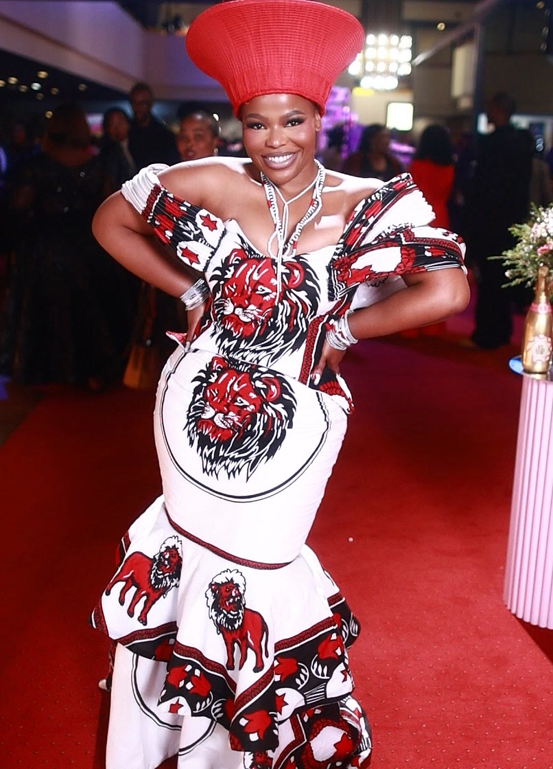 Guest in a red isicholo hat and printed gown at Basadi in Music, Johannesburg