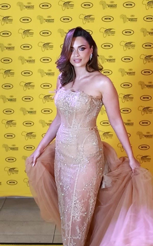 Guest in a nude embellished gown on the GlamBot® red carpet