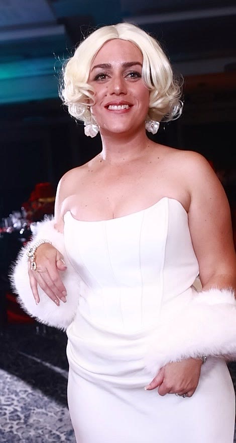 Guest in a white gown and faux-fur stole on the GlamBot® red carpet